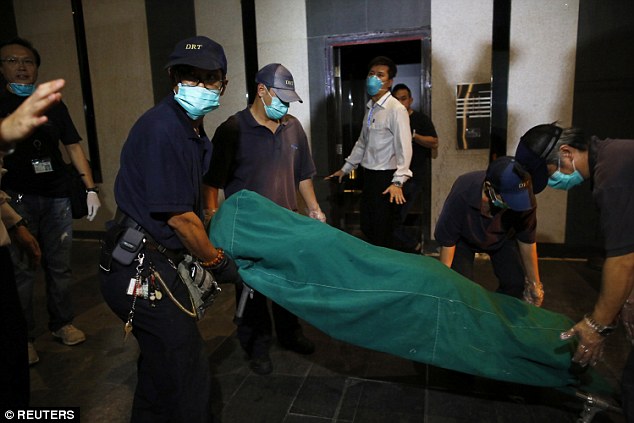 Government workers remove the body of a woman who was found dead at a flat in Hong Kongs Wan Chai district in the early hours of this morning. A British man was been arrested in connection with the murders