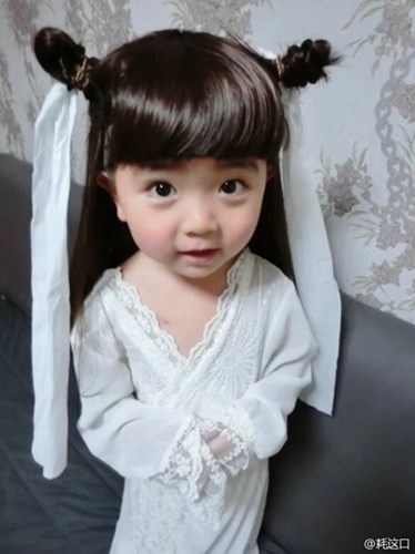 Khoác một chiếc áo trắng ren mỏng manh, tóc được buộc tạm kèm theo hai dải lụa trắng, cô nhóc Tong Meng Meng được mẹ hóa trang theo phong cách nàng Tiểu long Nữ Trần Nghiên Hy.