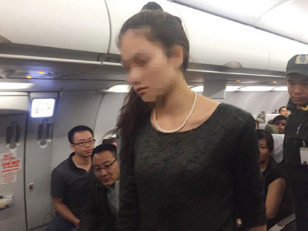 Một trong 2 nữ hành khách đánh nhau được an ninh đưa xuống máy bay.