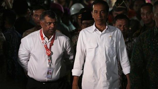 Indonesias President Joko Widodo (right) walking beside AirAsias CEO Tony Fernandes after meeting with family members of passengers onboard AirAsia flight QZ8501 in Juanda International Airport, Surabaya on Dec 30, 2014. -- PHOTO: REUTERS
