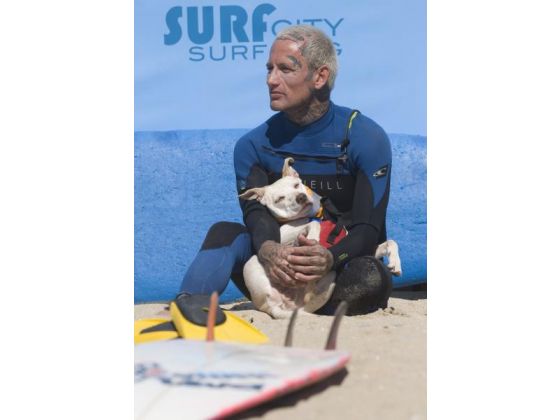 Ryan Rustan ở bãi biển Huntington Beach và chú chó của mình đang ngồi nghỉ lấy lại sức trong cuộc thi Surf City Surf Dog hôm chủ nhật vừa rồi.