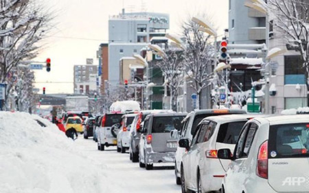 Dòng xe ô tô chầm chậm di chuyển trên đường phố Obihiro ngày 17/12.