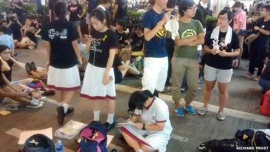 Học sinh, sinh viên vẫn tranh thủ làm bài tập ngay tại nơi biểu tình. Ảnh BBC