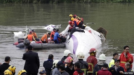 Rescuers pull a passenger out of the TransAsia Airways plane which crash landed in a river, in New Taipei City, February 4, 2015