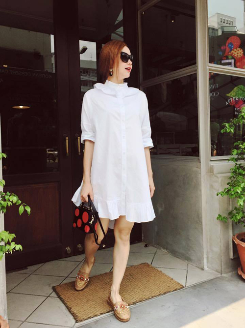 Váy sơ mi trắng với thiết kế thùng thình mang lại cảm giác thoải mái được Minh Hằng chọn lựa sử dụng trong những ngày nắng đầu mùa.