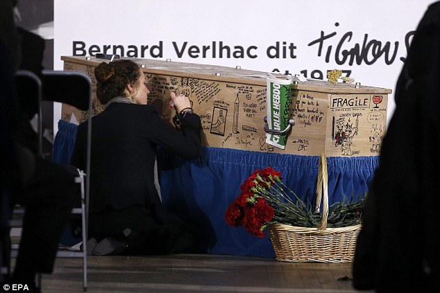 In his honour: A guest writes a message on Tignous coffin  during a funeral service held at the city hall