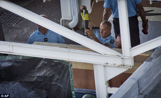 Members of the French gendarmerie seal a wooden box containing the wing part that was washed up on a beach on La Reunion island before putting it into a van ready to be placed onto a flight to France