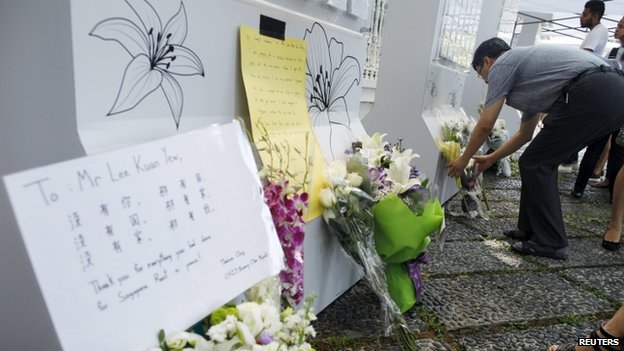 People lay flowers, as they mourn the passing of former prime minister Lee Kuan Yew, outside the Istana in Singapore, on 23 March 2015