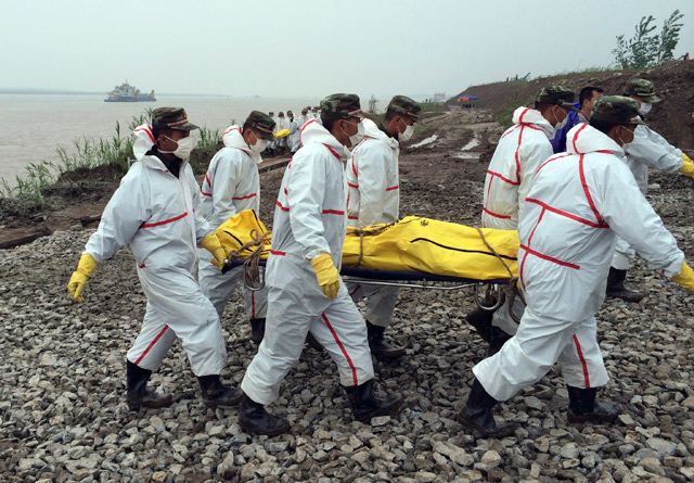 Rescue workers carry a body recovered from a capsized cruise ship in the Yangtze River in Jianli county in southern Chinas Hubei province.- AP