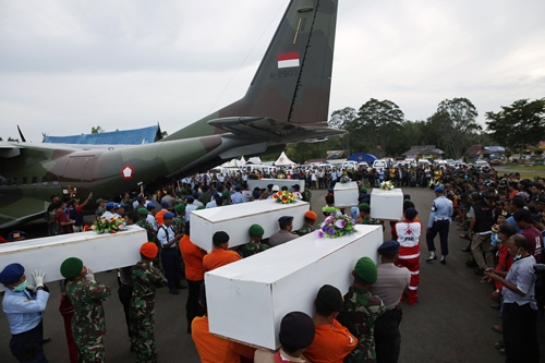 Caskets containing the remains of AirAsia QZ8501 passengers recovered from the sea are carried to a military transport plane before being transported to Surabaya, where the flight originated, at the airport in Pangkalan Bun, Central Kalimantan January 2, 2015. Ships and aircraft criss-crossed the seas off Borneo on Friday hunting for the wreck of the Indonesia AirAsia passenger jet, but bad weather was again hindering the search for the plane and the black box flight recorders that should reveal why it crashed. REUTERS/Darren Whiteside (INDONESIA - Tags: TRANSPORT MILITARY DISASTER TPX IMAGES OF THE DAY)