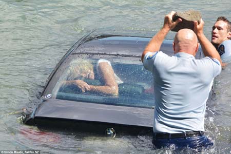 Người phụ nữ mặc kẹt trong chiếc xe BMW đang chìm nhanh (Ảnh: Fairfax NZ)