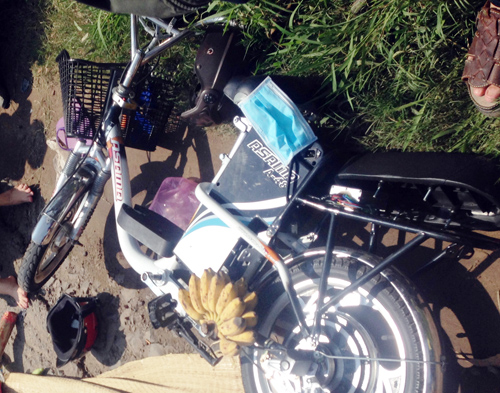 Xe đạp điện của hai mẹ con ngã xuống đường sau khi va chạm với xe tải. Ảnh: Hải Thuận.