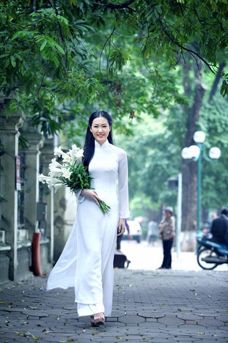 Á hậu Thùy Trang dịu dàng sải bước trên đường Hà Nội với bó hoa Loa kèn trên tay.