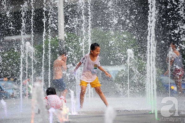 Trẻ em thích thú đùa nghịch giữa đài phun nước trong thời tiết nắng nóng