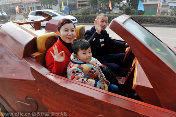 Yu drives his homemade wooden sports car with his family on a road in Guangfeng county.