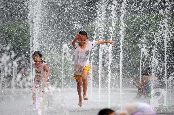 Trẻ em thích thú đùa nghịch giữa đài phun nước trong thời tiết nắng nóng