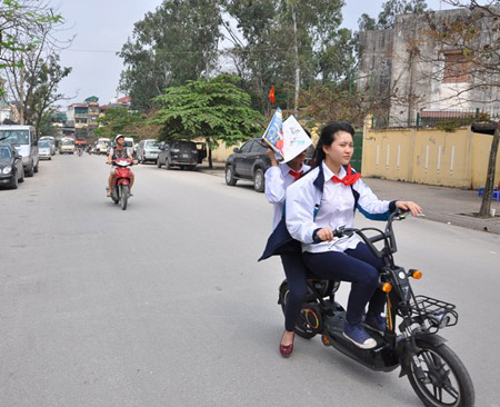 Nhiều học sinh phổ thông đi xe máy điện đến trường.