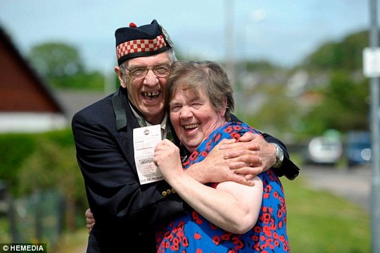 Vợ chồng ông Geordie Rhodick hạnh phúc với tờ vé số trúng giải. Ảnh: HEMEDIA