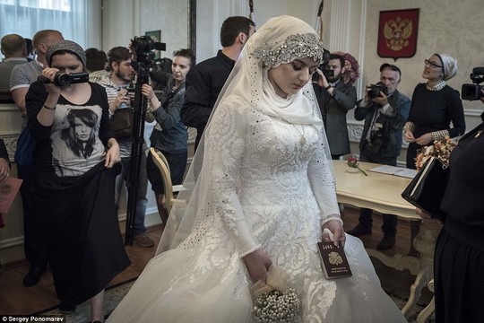 Not the happiest day of her life: Chechen teenager Kheda Goilabiyeva clutches a passport as she looks down despondently after being forced to marry an ally of Chechen strongman Ramzan Kadyrov who reportedly threatened to kidnap her if she and her parents refused to comply