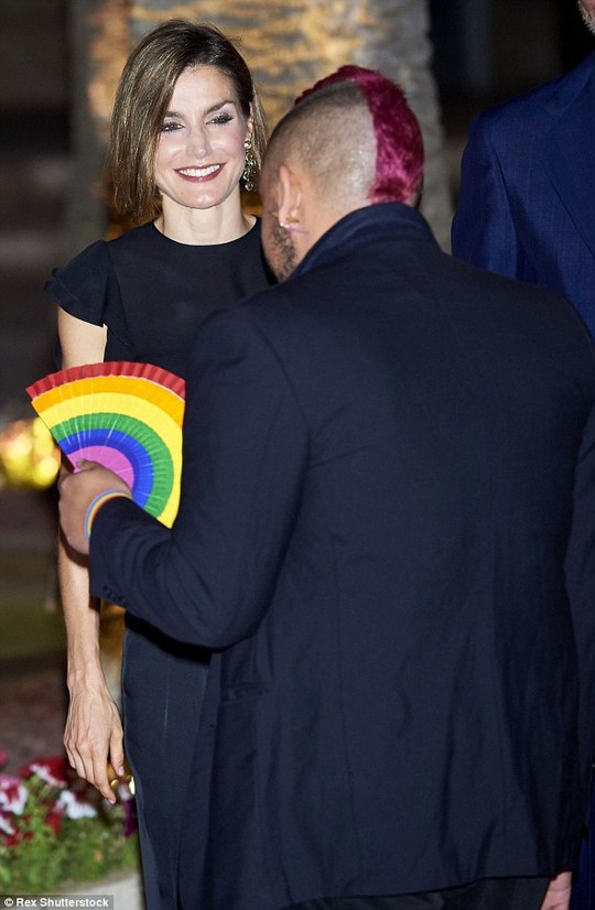 All smiles: Letizia beams as she chats to a man with a quirky purple mohican and a rainbow fan