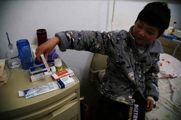 Chen Minghao, the 9-year-old with leukemia, says he is not afraid of taking the medicines on the desk at the hospitals ward in Hefei, capital city of East Chinas Anhui province on Monday. He says he wants to beat the leukemia and go back to study with his classmates.