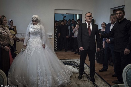 Sorrow: The 17-year-old looked despondent throughout the ceremony as Chechen warlord Ramzan Kadyrov watched on from the crowd