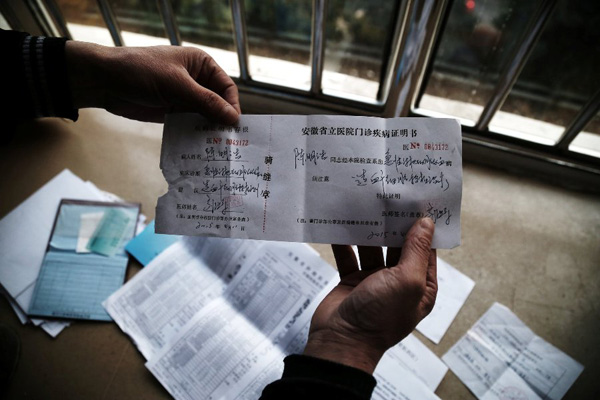 Chen Yuntao shows the diagnosis issued by Anhui Provincial Hospital on Monday. Chen says that he will use this certificate to apply for severe illness aid in his hometown.