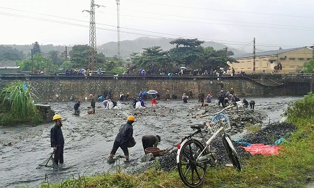 Giữa mưa lũ, nhiều người bất chấp nguy hiểm, xuống đường mót than do trước đó than xỉ tràn xuống đường