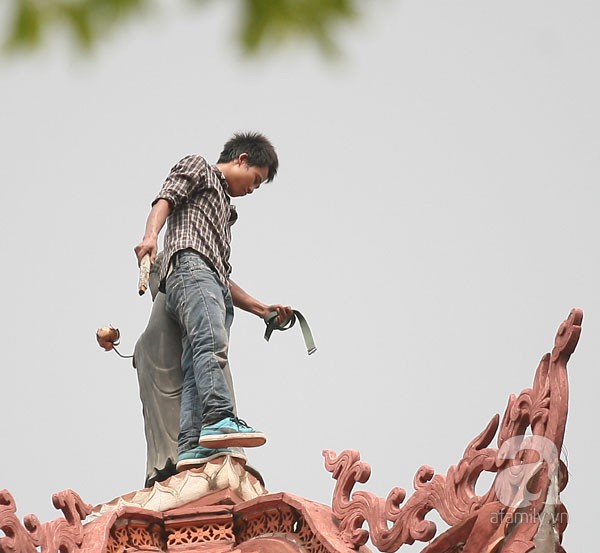 Trên tay nam thanh niên cầm cán búa, dây thắt lưng liên tục nhảy nhót quanh tượng Phật trên bảo tháp