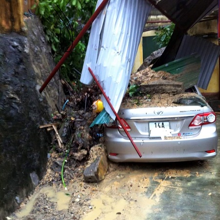 Chiếc xe ô tô của một nhà dân bị hư hại nặng do mái nhà xe đổ sập