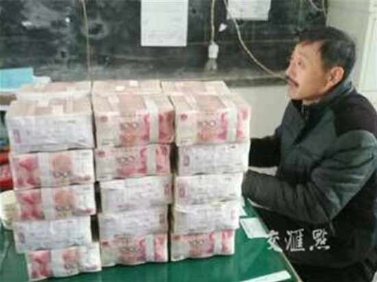 
&Ocirc;ng Wang Yong mang một chồng tiền mặt tới ủy ban l&agrave;ng.
