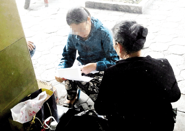 
“Cò” vé tàu (ảnh trái) đang giao dịch với khách hàng ngay trên phố Lê Duẩn, trước cổng ga Hà Nội. Ảnh: Nhật Tân
