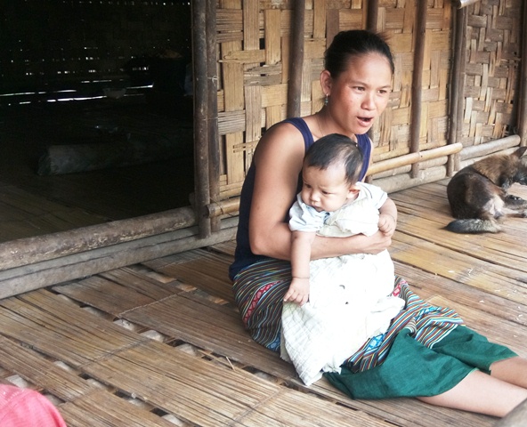 Một người phụ nữ người dân tộc Ma - Coong bế đứa con nhỏ và bày tỏ sự lo lắng khi hoa màu, lúa trên rẫy đã bị mưa lũ làm hư hại hết