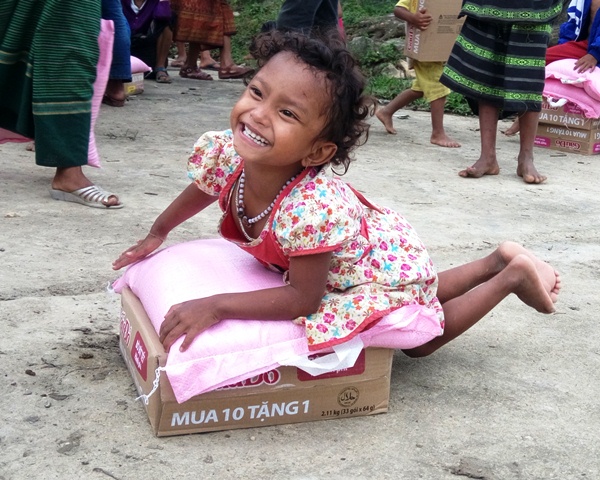 Những em bé người A - Rem (xã Tân Trạch) cười rạng rỡ khi bê thùng mì tôm trong tay