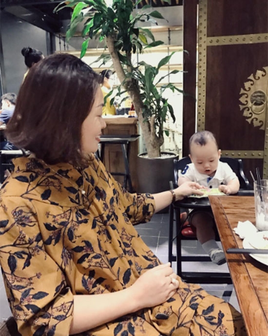 Bé Khoai Tây ngồi chơi cùng bà ngoại bên bàn ăn. Ảnh: Instagram.