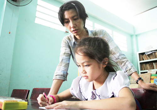 
C&ocirc; Chi dạy học tr&ograve; viết chữ. Ảnh: Mạnh T&ugrave;ng
