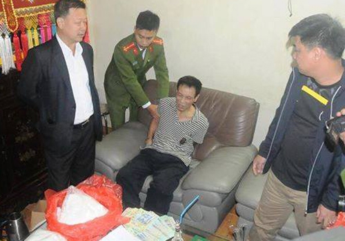 Nghi can Thạch Văn H&ograve;a (&aacute;o kẻ, cộc tay) khi bị bắt quả tang.