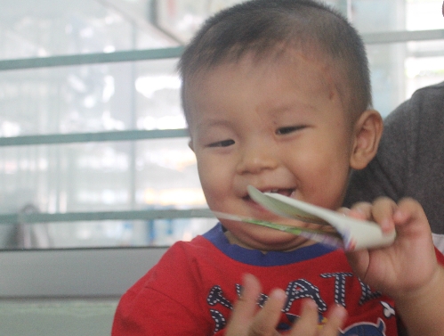 Cậu bé mọc được 10 chiếc răng sữa, thích thú cười đùa cùng mọi người. Ảnh: Lê Phương.