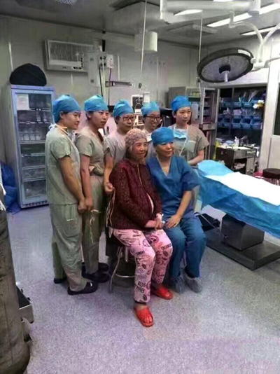 
Cụ b&agrave; với bụng bầu lớn chụp c&ugrave;ng k&iacute;p mổ trước khi ca phẫu thuật diễn ra. Ảnh: AsiaWire
