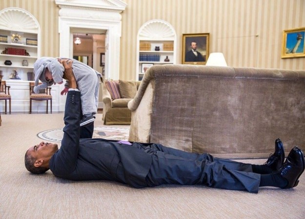 
Ông Obama nằm kềnh cang với một nhóc tỳ trong phòng tại Nhà Trắng.
