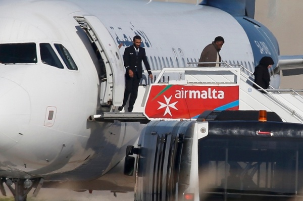 
Một số hành khách bắt đầu bước ra khỏi chiếc máy bay bị không tặc. Ảnh: Reuters
