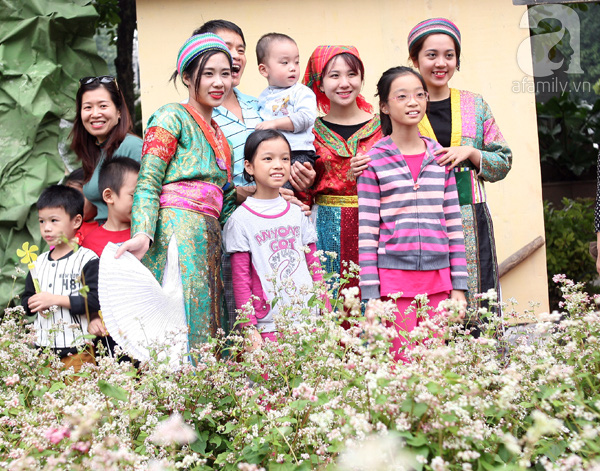 
Cả gia đình chụp với các cô gái Mông bên vườn tam giác mạch giữa Thủ đô.
