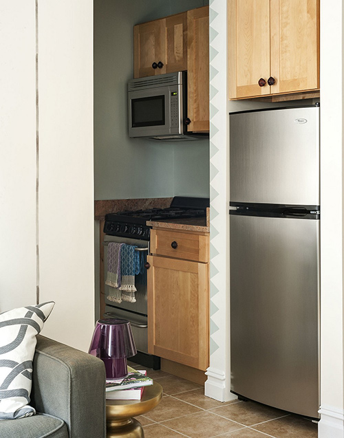 Phòng bếp đầy đủ tiện nghi mà vẫn sạch gọn. Màu gỗ nâu nhạt bổ sung thêm sự ấm cúng cho gian nhà.