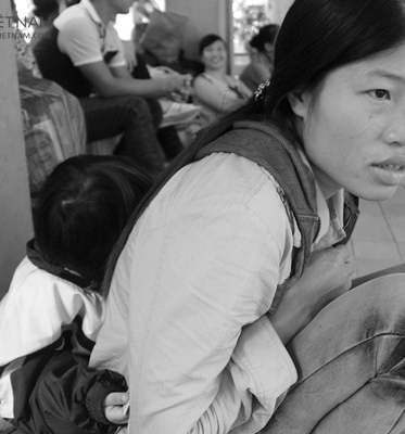 Hai mẹ con bé Nhi ngồi vật vờ ở cổng Bệnh viện Nhi Hà Nội.