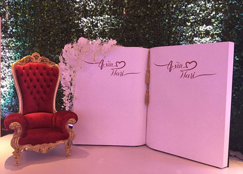 Nơi các khách mời ghi lời chúc đến cô dâu, chú rể được thiết kế như một quyển sổ kỷ niệm cỡ lớn, trang trí bên cạnh là một chiếc ghế đỏ nổi bật.