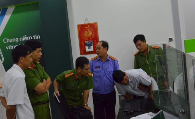 
Lực lượng chức năng khám nghiệm hiện trường vụ cướp tại Vietcombank chi nhánh Duyên Hải.
