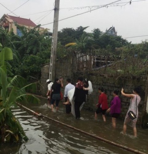 Chú rể bế cô dâu lội qua dòng nước lũ về nhà chồng