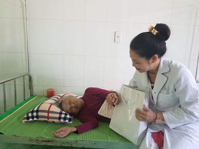 Một cụ b&agrave; hơn 90 tuổi bị u cằm v&agrave; liệt đang cố gắng mở mắt để tiếp nhận sự quan t&acirc;m của c&aacute;c nh&agrave; hảo t&acirc;m.