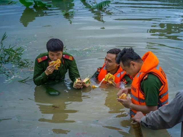 Ăn vội miếng bánh mì để tiếp tục công việc đắp đê