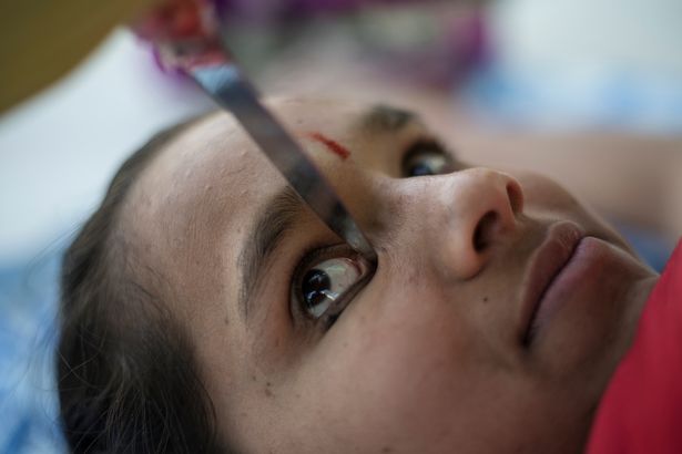 
Anamika Kothari giữ dao bằng đầu gối để kẻ mắt

